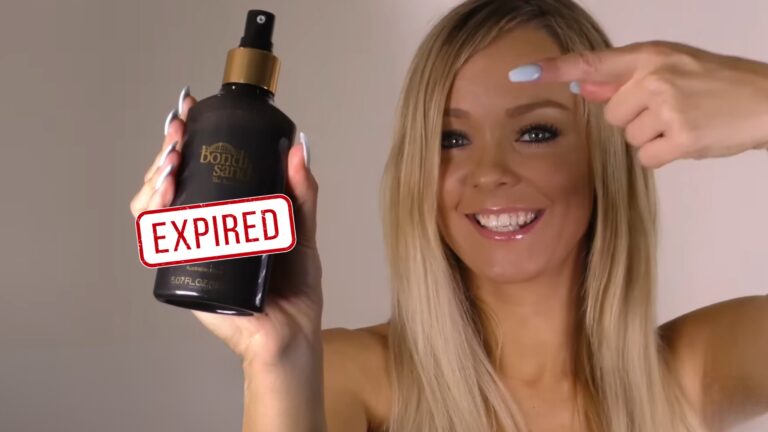 A woman with long blonde hair is pointing at a bottle of Bondi Sands self-tanning product, which she is holding up. The bottle has a bold 'EXPIRED' stamp over it, suggesting the content relates to how long Bondi Sands lasts before it expires.