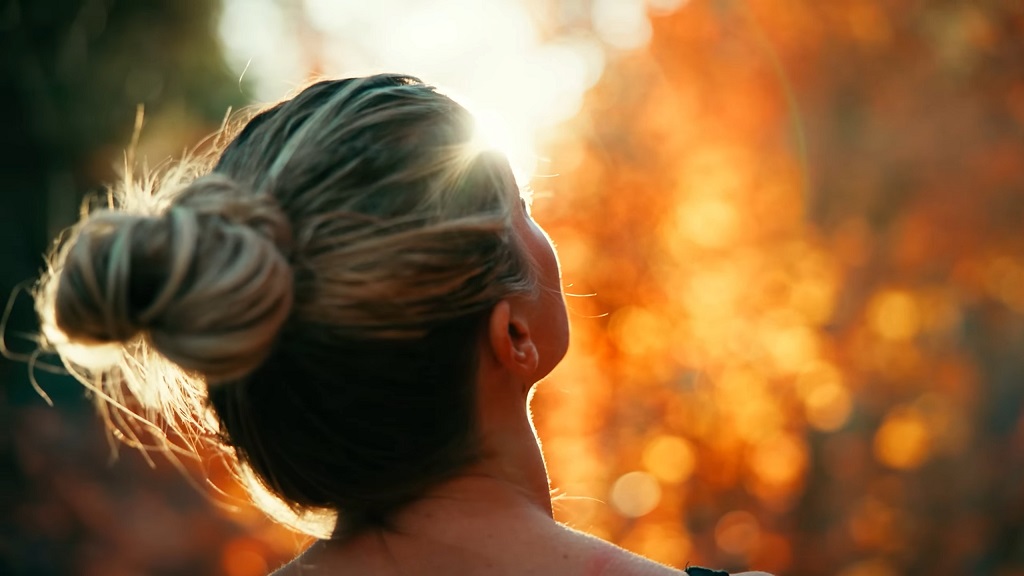 A girl is standing in the sun